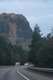 Trucks on a highway below a mountain